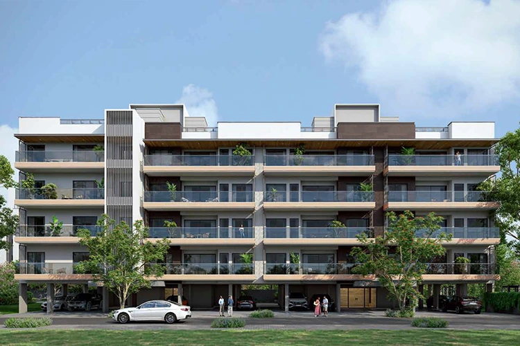 Birla Avik contemporary multi-story residential building with glass balconies, landscaped greenery, parking area on ground floor, and people near the entrance on a pleasant day.